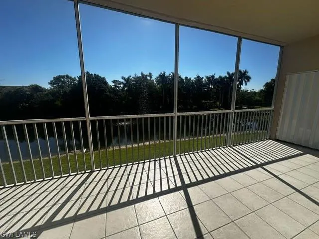 Unfurnished sunroom featuring view of wooded area