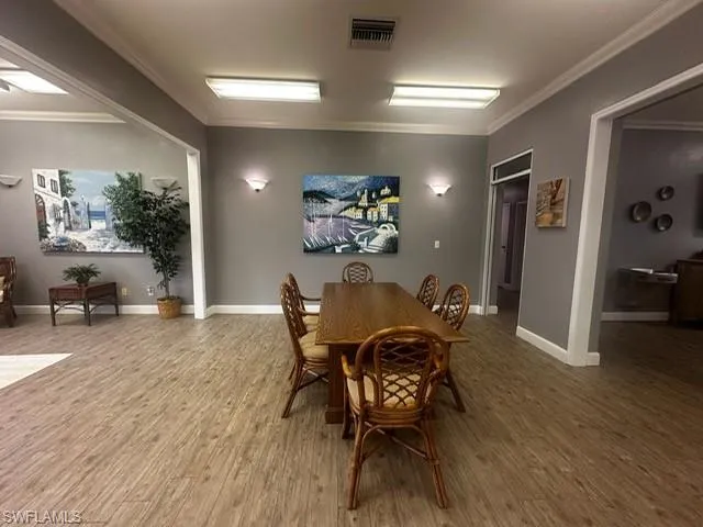 Dining area featuring crown molding and wood finished floors