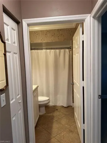 Full bath with vanity and dark tile patterned flooring