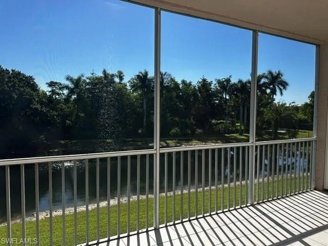 Unfurnished sunroom with a water view and view of scattered trees