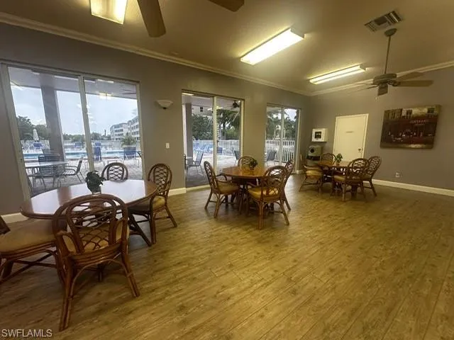 Dining room with a ceiling fan, crown molding, and wood finished floors