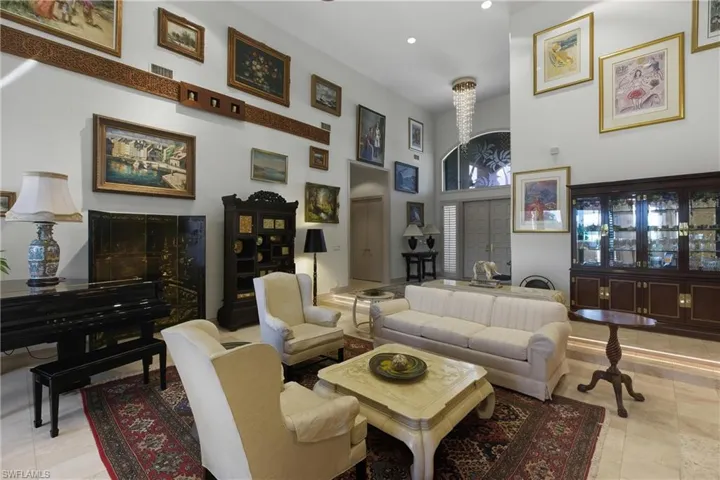 Living area featuring a towering ceiling, light tile patterned flooring, and recessed lighting