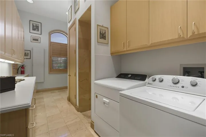 Laundry room featuring independent washer and dryer and cabinet space