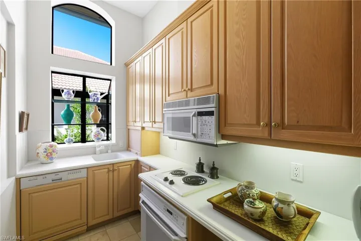 Kitchen with white appliances, light countertops, and light tile patterned flooring