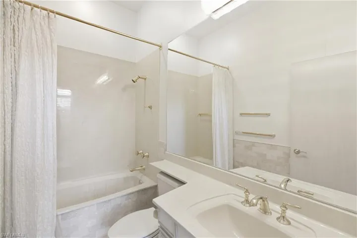 Full bathroom with shower / tub combo with curtain and vanity