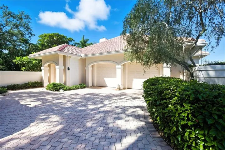 Mediterranean / spanish-style house with a garage, stucco siding, decorative driveway, and a tiled roof