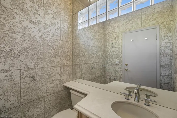 Bathroom with vanity and tile walls