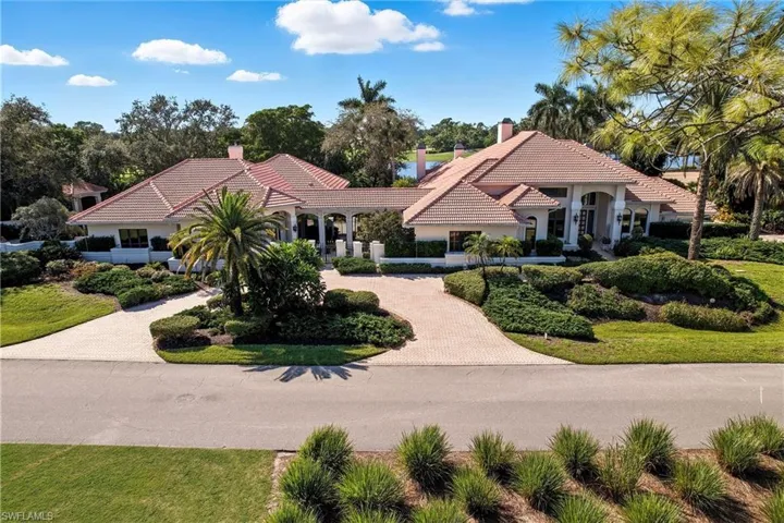 Mediterranean / spanish-style home featuring a chimney, decorative driveway, and a front yard