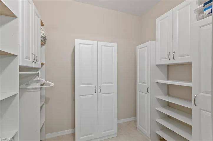 Walk in closet with light tile patterned flooring