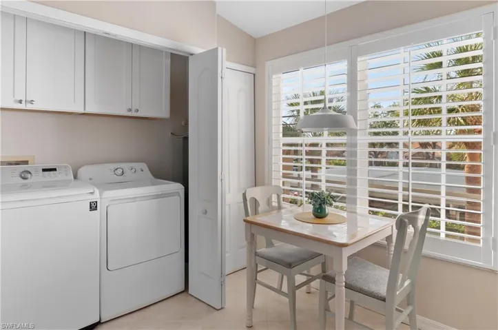 Laundry area with cabinets, plenty of natural light, and washer and clothes dryer