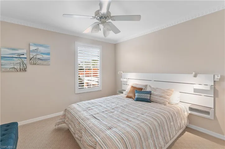 Bedroom featuring crown molding, light colored carpet, and ceiling fan