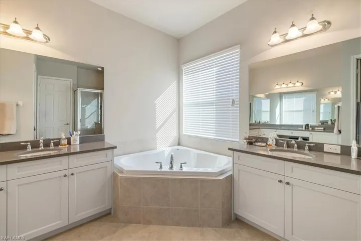 Bathroom featuring tile patterned floors, shower with separate bathtub, and vanity