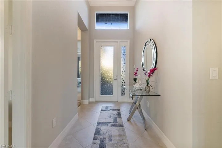Tiled foyer with a towering ceiling