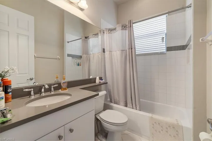 Full bathroom with shower / tub combo with curtain, vanity, and toilet