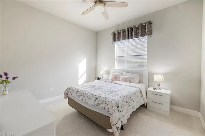 Carpeted bedroom featuring ceiling fan