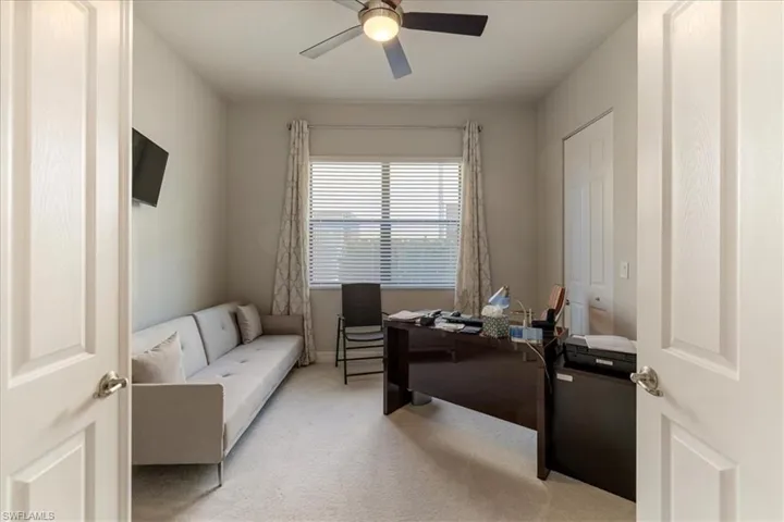 Office space with light carpet and ceiling fan