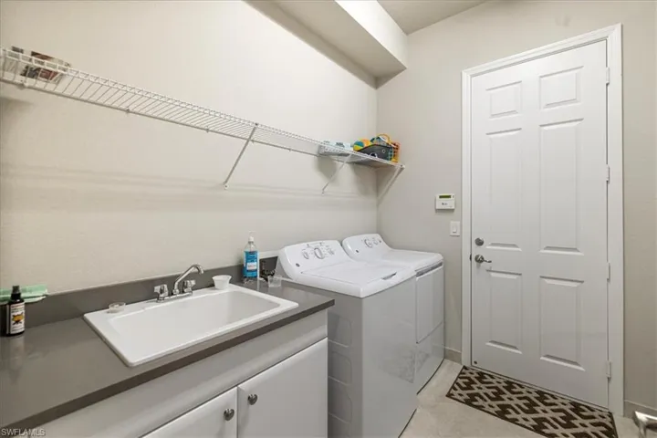 Washroom featuring cabinets, sink, and washer and clothes dryer