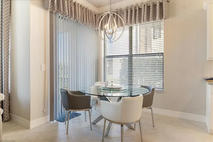 Dining room with light tile patterned flooring, ornamental molding, and a chandelier