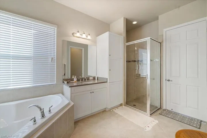 Bathroom with vanity, independent shower and bath, and tile patterned flooring