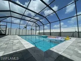 View of swimming pool with a patio and glass enclosure