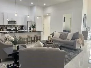 Living area with recessed lighting, marble finish floors, and a high ceiling