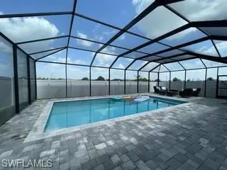 Outdoor pool with a patio area and glass enclosure