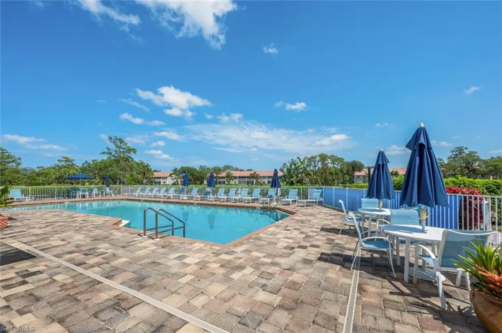Community pool with a patio and outdoor dining space