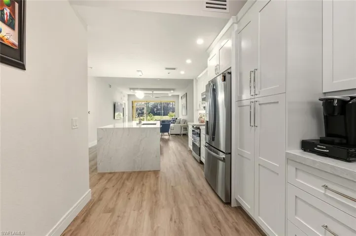Kitchen featuring recessed lighting, stainless steel appliances, white cabinetry, and open floor plan