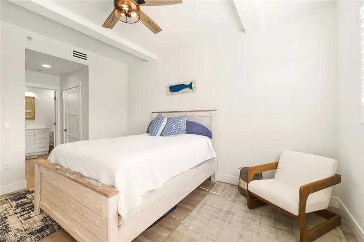 Bedroom featuring wood finished floors, ceiling fan, ensuite bath, and recessed lighting