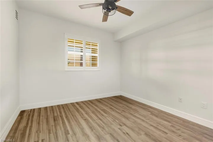 Empty room with wood finished floors and ceiling fan