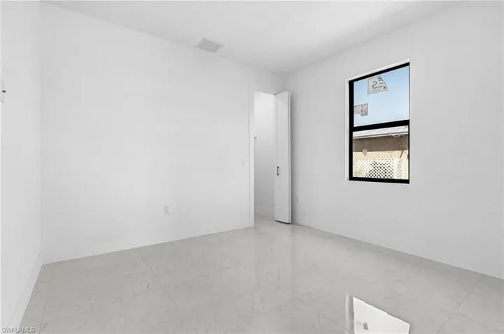 Unfurnished room featuring visible vents, marble finish floor, and baseboards
