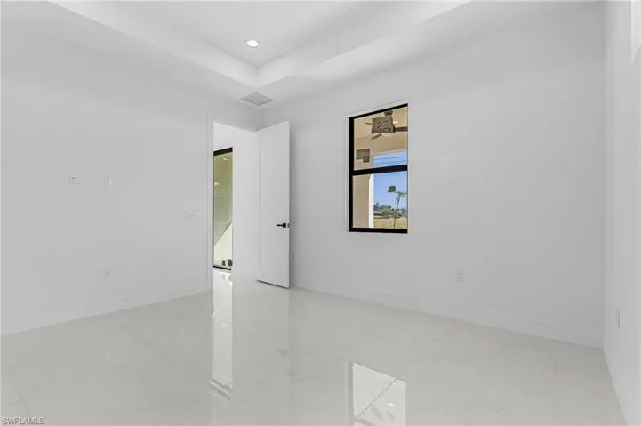 Spare room with recessed lighting, visible vents, baseboards, and a raised ceiling