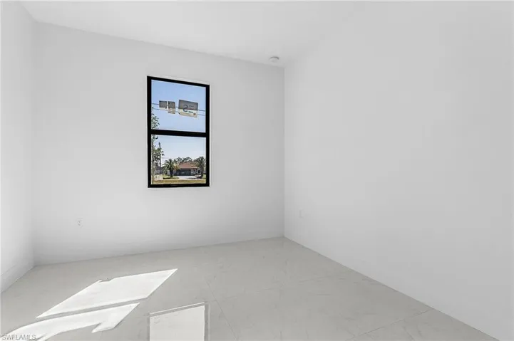 Unfurnished room featuring marble finish floor and baseboards