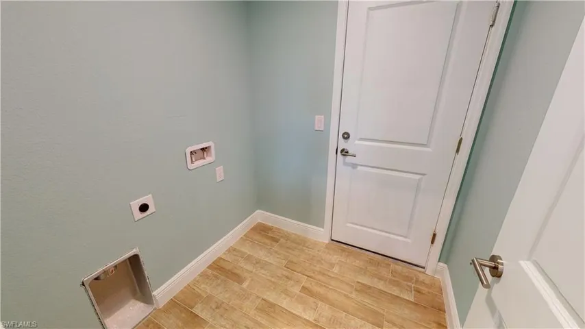 Laundry area with light wood-style flooring, washer hookup, and hookup for an electric dryer