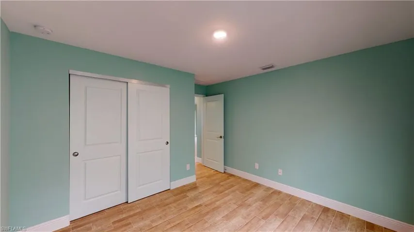 Unfurnished bedroom featuring light wood finished floors and a closet
