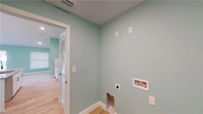 Laundry room featuring light wood-style flooring, hookup for an electric dryer, recessed lighting, and hookup for a washing machine