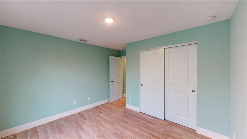 Unfurnished bedroom with light wood-style floors and a closet