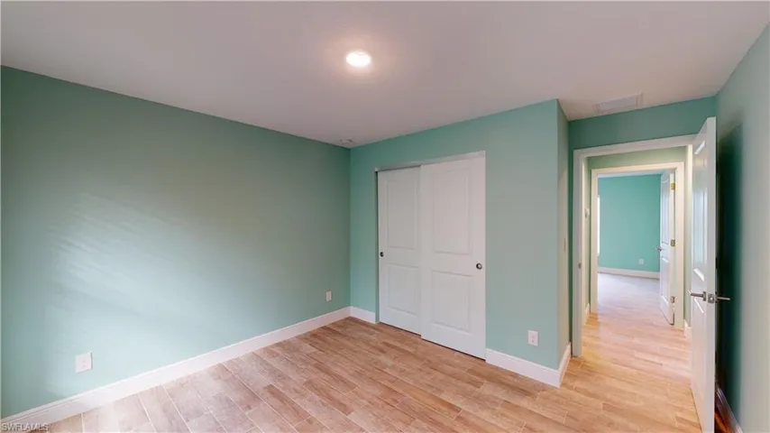 Unfurnished bedroom with light wood finished floors and a closet