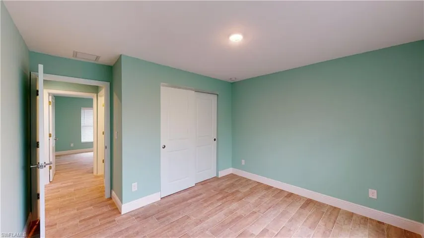 Unfurnished bedroom featuring light wood-style flooring and a closet