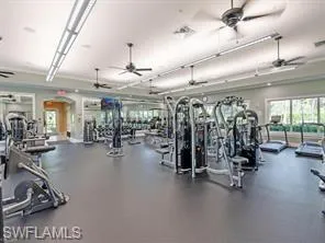 Exercise room featuring a ceiling fan and arched walkways