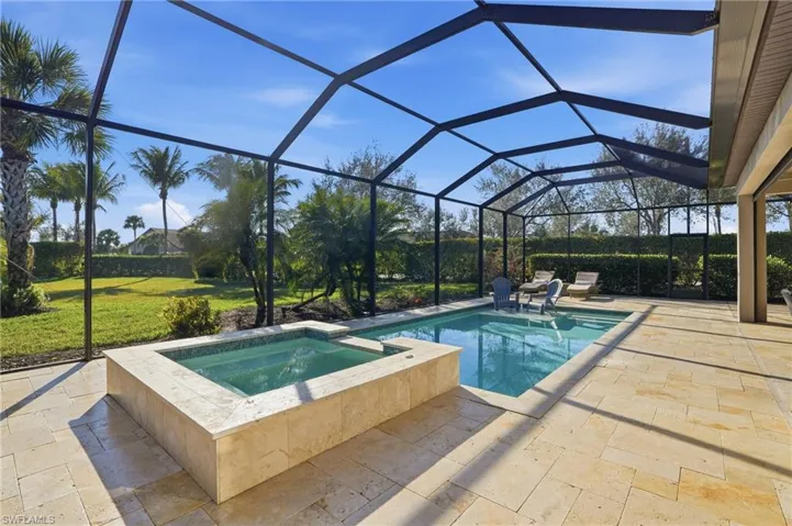 Integrated pool / spa with a sunroom, a private area, cage enclosure, and a privately landscaped yard