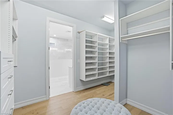 Walk in closet with light wood-style flooring