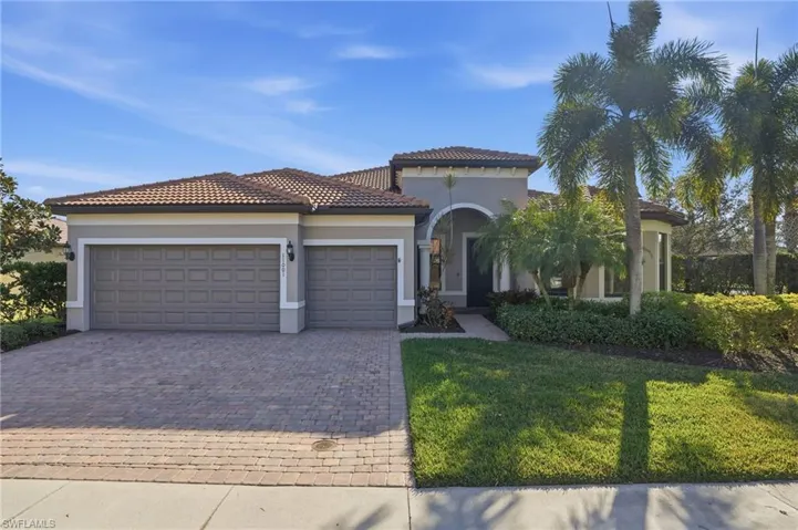 Mediterranean / spanish house featuring an attached garage, decorative driveway, stucco siding, a front yard, and a tiled roof
