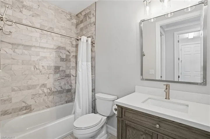 Bathroom featuring vanity and shower / tub combo with curtain