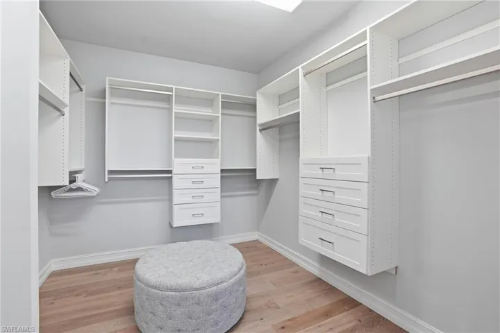 Walk in closet with light wood-style floors