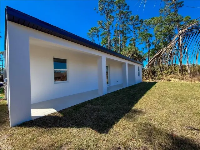 View of side of property featuring stucco siding and a lawn