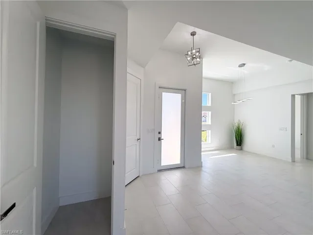 Foyer with baseboards and a chandelier