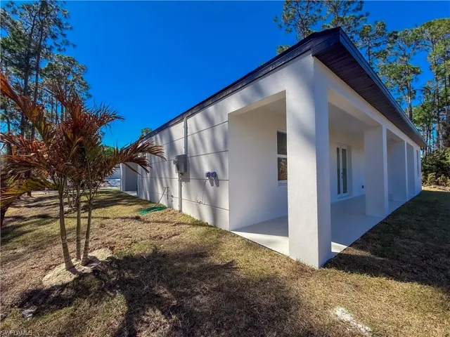 View of property exterior with stucco siding and a lawn