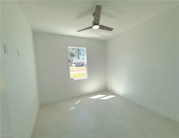 Spare room with baseboards and ceiling fan