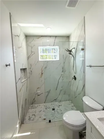 Master bathroom featuring vanity and a marble finish shower